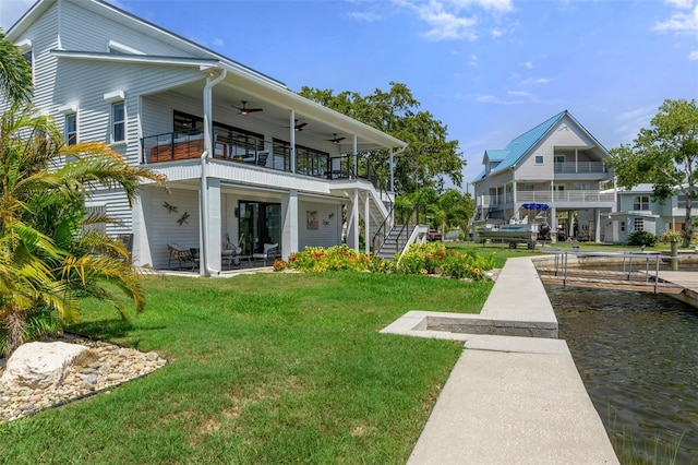 back of property with stairs, a lawn, a ceiling fan, and a balcony