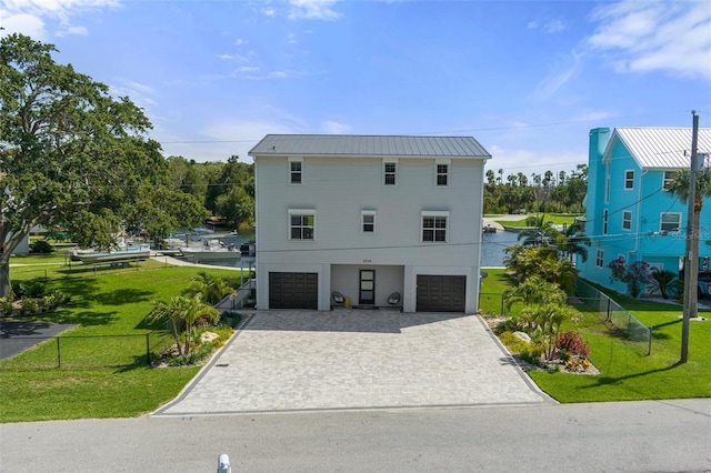 view of side of home with an attached garage, decorative driveway, and metal roof