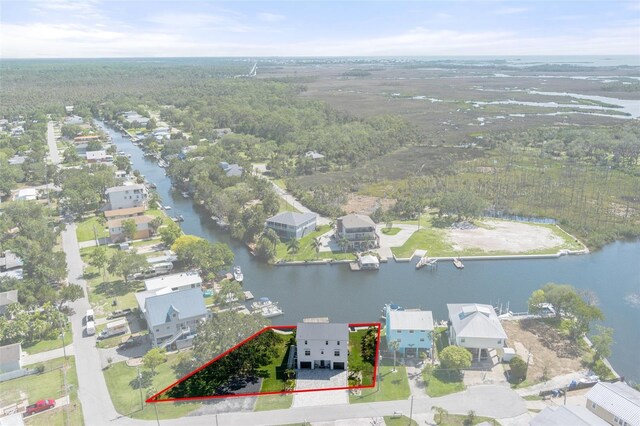 aerial perspective of suburban area with property parcel outlined, a nearby body of water, and a forest