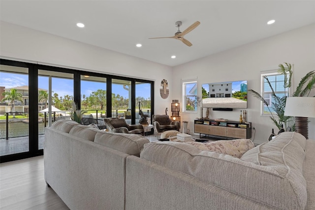 living room featuring recessed lighting, a ceiling fan, and light wood-style flooring