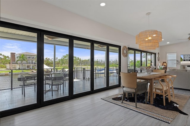 dining space featuring plenty of natural light, wood finished floors, recessed lighting, and a water view