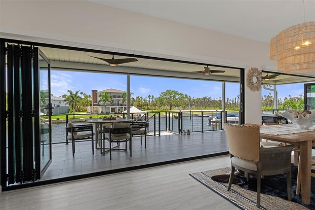 dining area featuring a water view, wood finished floors, and ceiling fan