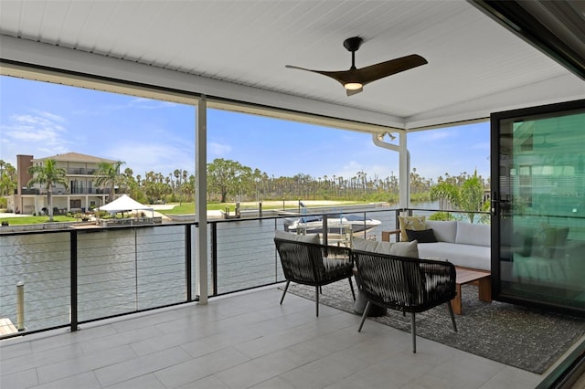 sunroom featuring a ceiling fan, a water view, an outdoor living space, and healthy amount of natural light