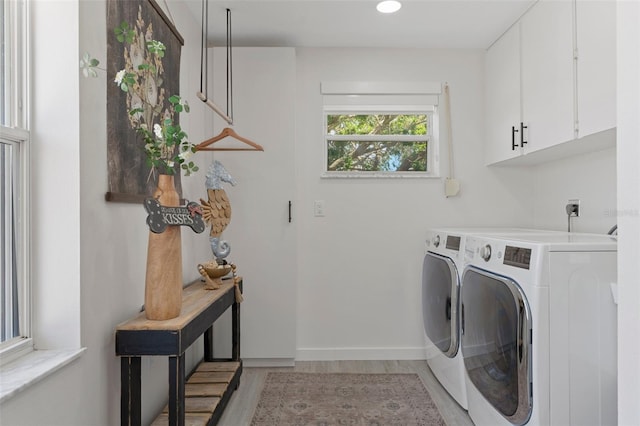 clothes washing area with cabinet space, washer and clothes dryer, light wood-type flooring, recessed lighting, and baseboards