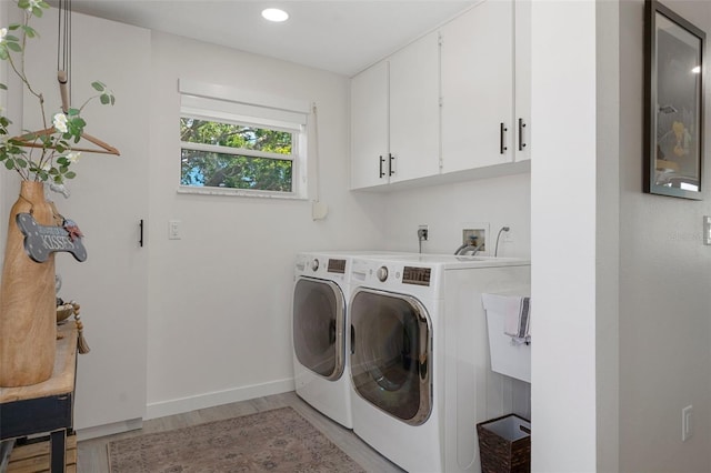 washroom featuring cabinet space, separate washer and dryer, light wood-style flooring, baseboards, and recessed lighting