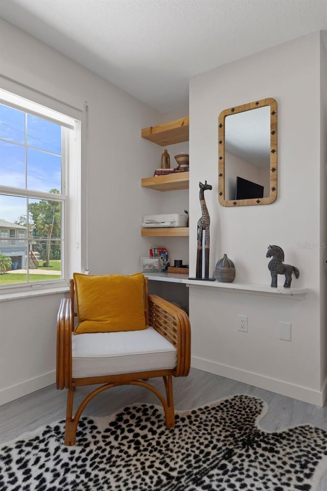 sitting room with wood finished floors and baseboards