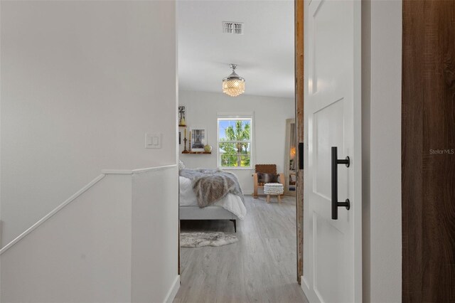 hallway with wood finished floors and an upstairs landing