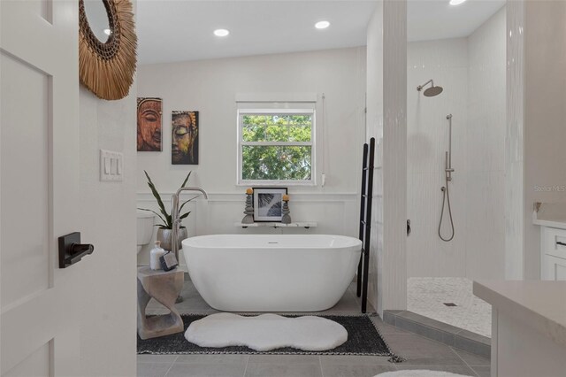 full bath with a freestanding bath, walk in shower, tile patterned flooring, and recessed lighting