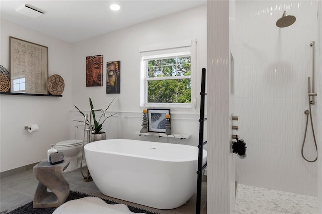 full bathroom featuring toilet, a tile shower, and a freestanding tub