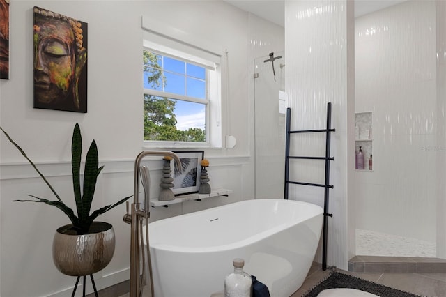 full bathroom featuring a walk in shower, a soaking tub, a decorative wall, and tile patterned floors