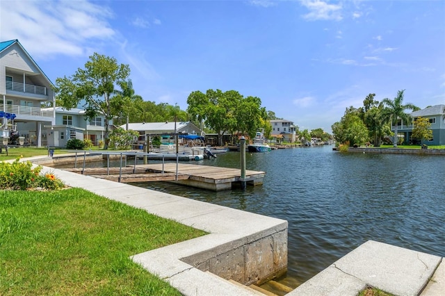 dock featuring a water view, a residential view, and a lawn