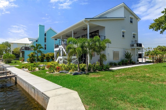 view of home's exterior with a ceiling fan, a lawn, and stairs