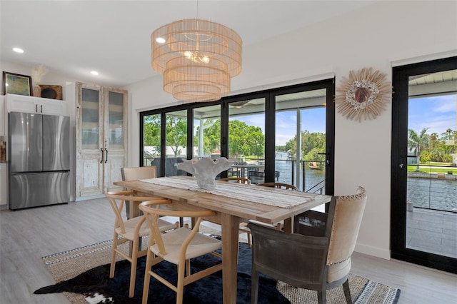 5234 Foxhall Ct, Weeki Wachee, FL 34607 - dining area with light wood-style flooring, a chandelier, recessed lighting, baseboards, and a water view