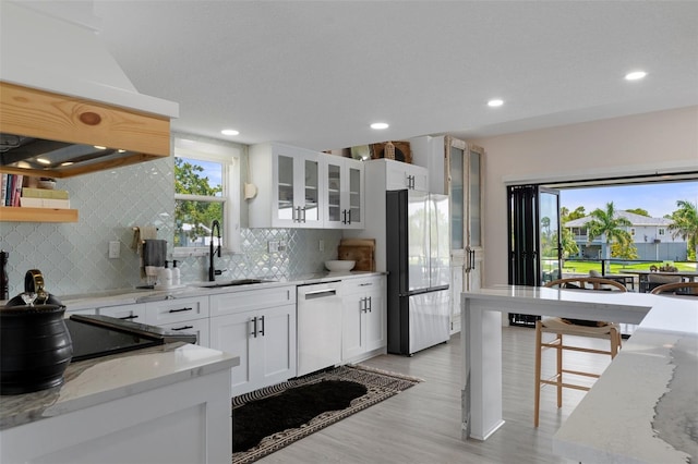 5234 Foxhall Ct, Weeki Wachee, FL 34607 - kitchen featuring freestanding refrigerator, dishwasher, a sink, custom range hood, and plenty of natural light
