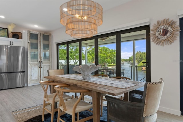 5234 Foxhall Ct, Weeki Wachee, FL 34607 - dining area featuring light wood-style flooring, a chandelier, recessed lighting, a water view, and baseboards