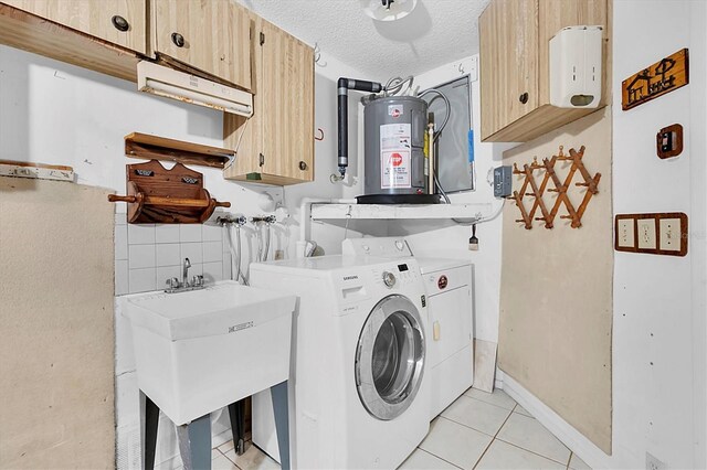 4837 Boonesboro Ct, New Port Richey, FL 34655 - laundry area with cabinet space, water heater, washing machine and clothes dryer, light tile patterned flooring, and a textured ceiling
