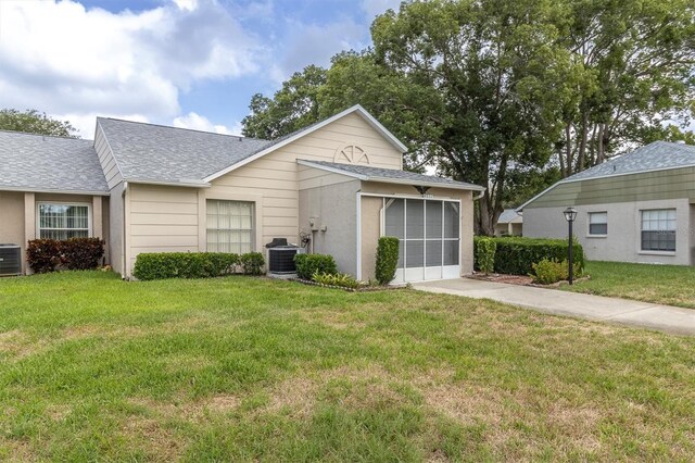 4837 Boonesboro Ct, New Port Richey, FL 34655 - view of front facade with a shingled roof, central air condition unit, driveway, a front yard, and a garage
