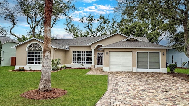 ranch-style home with stucco siding, decorative driveway, a garage, a front yard, and roof with shingles
