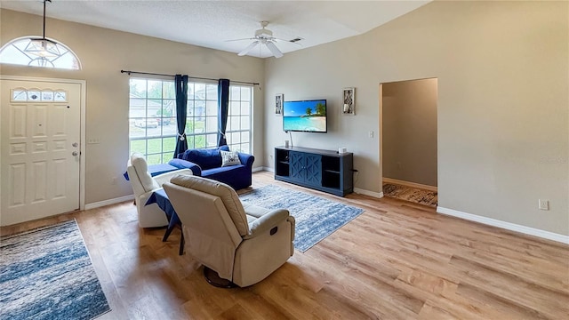 living area featuring light wood-type flooring, ceiling fan, and baseboards