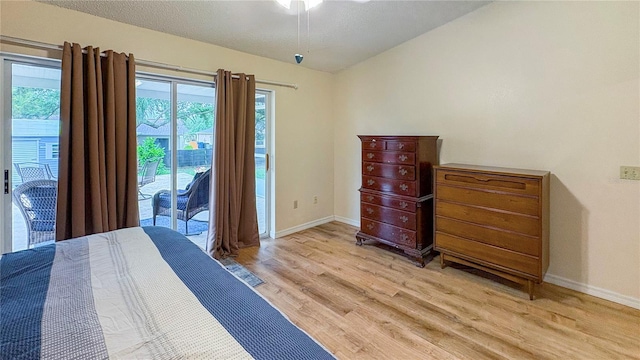 bedroom with access to outside, light wood-type flooring, lofted ceiling, multiple windows, and baseboards