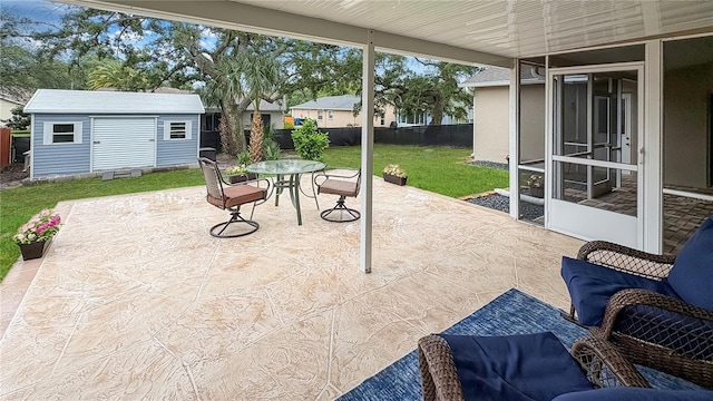 view of patio featuring a shed, outdoor dining area, an outbuilding, and a sunroom