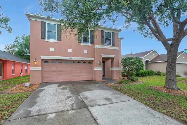 view of front facade with an attached garage, stucco siding, and concrete driveway