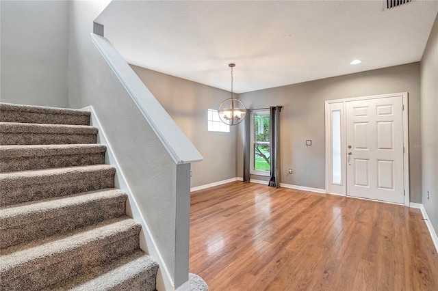 entrance foyer featuring wood finished floors, stairway, a chandelier, baseboards, and recessed lighting