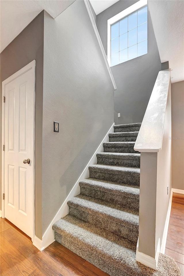 staircase with wood finished floors and baseboards