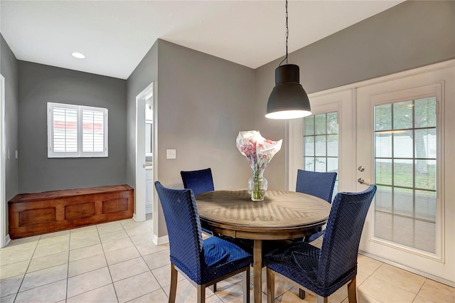 dining space with plenty of natural light, light tile patterned floors, french doors, and baseboards