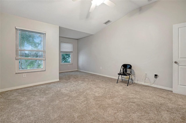 carpeted empty room featuring vaulted ceiling, a ceiling fan, and baseboards
