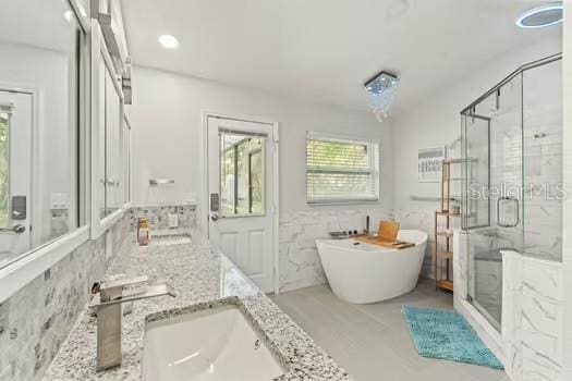 5216 Hope Ln, Spring Hill, FL 34606 - bathroom featuring a shower stall, a freestanding bath, and double vanity