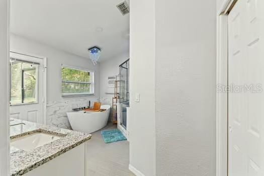 5216 Hope Ln, Spring Hill, FL 34606 - full bath featuring a soaking tub, vanity, and a shower with door
