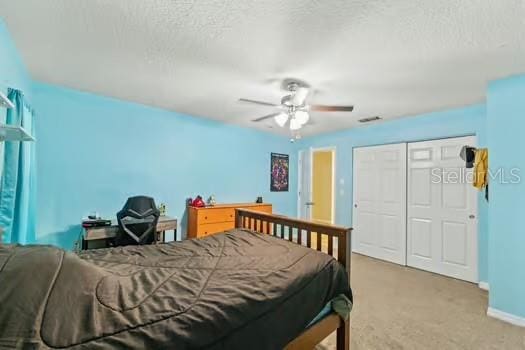 5216 Hope Ln, Spring Hill, FL 34606 - carpeted bedroom featuring a closet, baseboards, a textured ceiling, and a ceiling fan