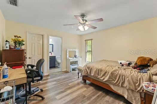 5216 Hope Ln, Spring Hill, FL 34606 - bedroom with wood finished floors, ensuite bathroom, and ceiling fan