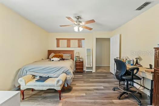 5216 Hope Ln, Spring Hill, FL 34606 - bedroom with wood finished floors, a desk, and ceiling fan