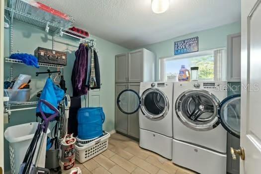 5216 Hope Ln, Spring Hill, FL 34606 - laundry area featuring washing machine and dryer and cabinet space