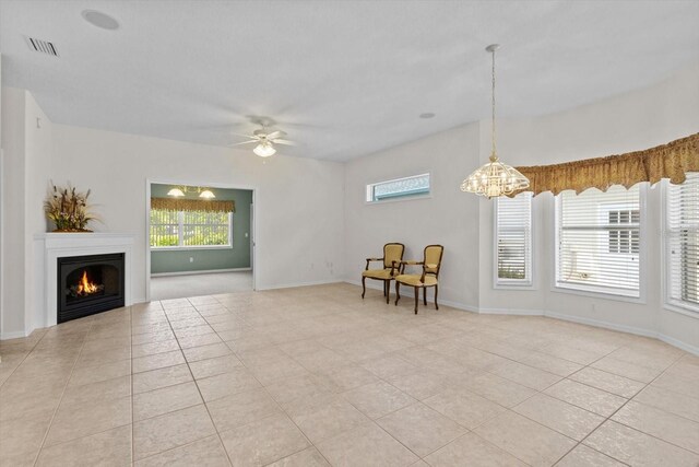 6240 W Glynborne Loop, Crystal River, FL 34429 - living room featuring light tile patterned flooring, a warm lit fireplace, ceiling fan, a chandelier, and baseboards