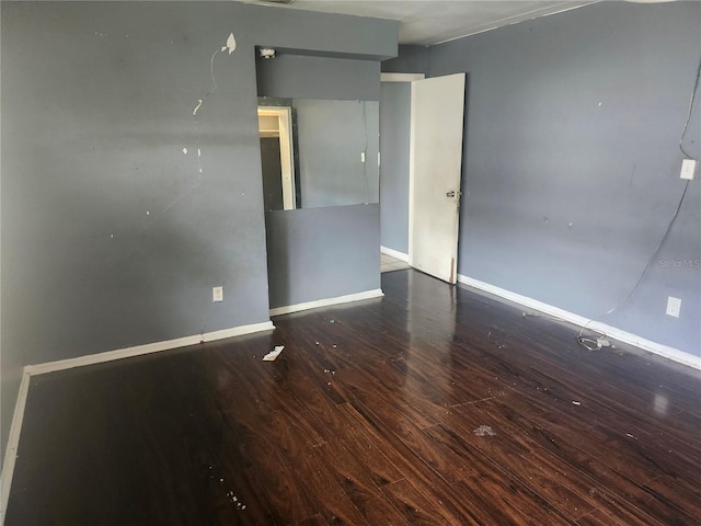 spare room with hardwood / wood-style flooring and baseboards