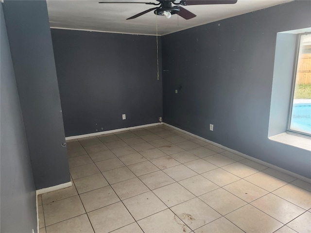 unfurnished room with a ceiling fan, light tile patterned floors, and baseboards