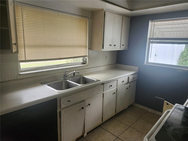 kitchen featuring a sink, tasteful backsplash, light tile patterned floors, and light countertops