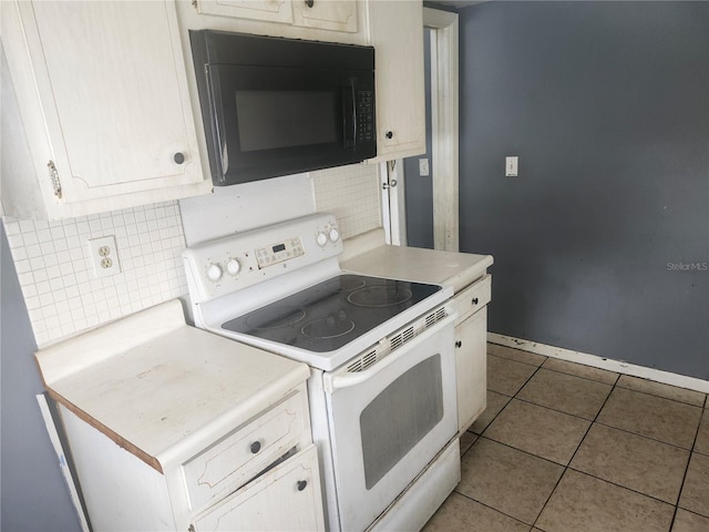 kitchen featuring electric stove, black microwave, light countertops, tasteful backsplash, and tile patterned floors