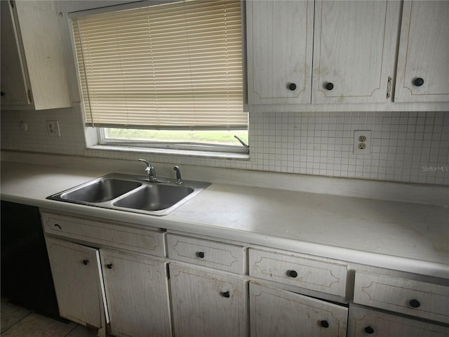 kitchen featuring a sink, light countertops, and tasteful backsplash