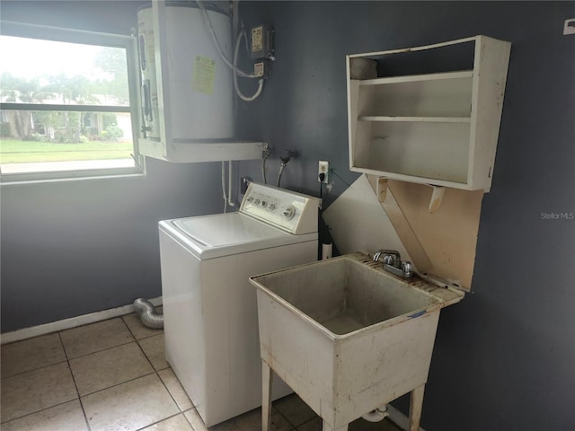 laundry area featuring washer / clothes dryer, water heater, tile patterned flooring, and baseboards