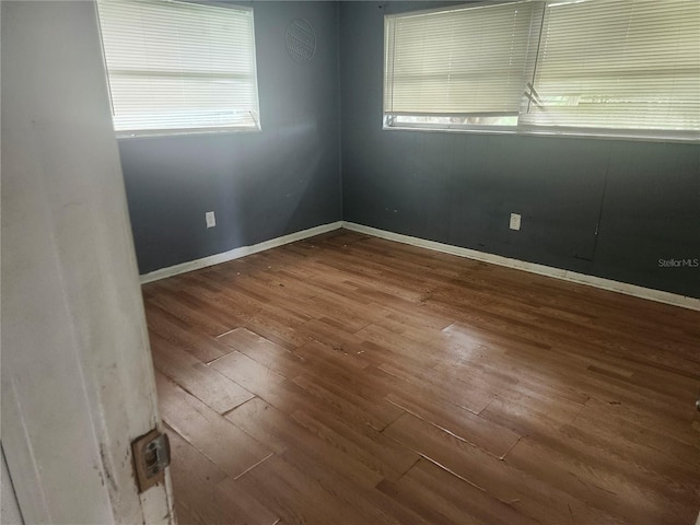 unfurnished room with wood finished floors and baseboards