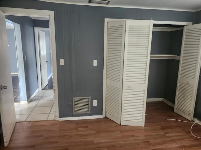 unfurnished bedroom featuring a closet, baseboards, and light wood-style flooring