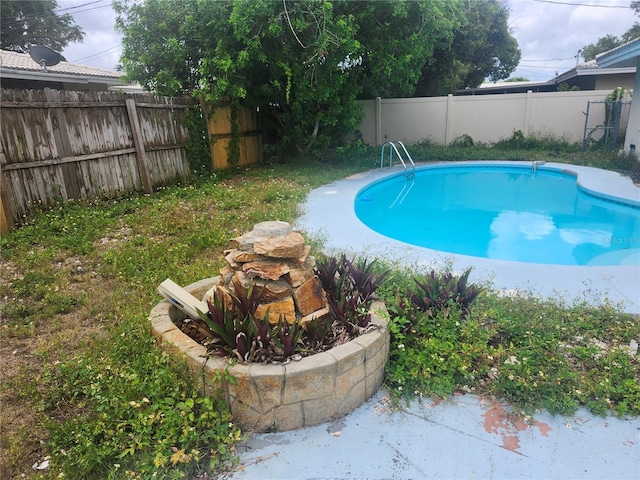view of swimming pool with a fenced backyard