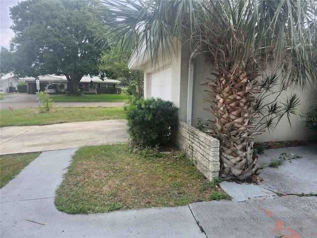 view of side of home featuring stucco siding and a garage