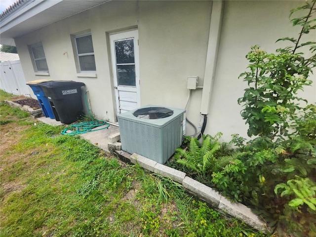 exterior view of central AC, stucco siding, and fence