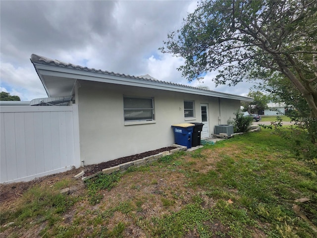 view of side of property featuring stucco siding and central air condition unit