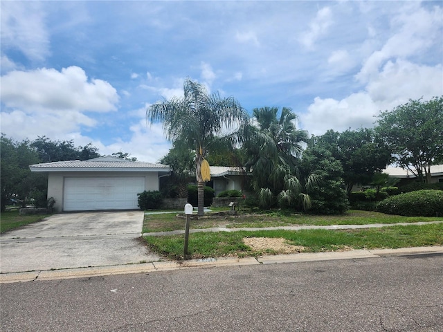 view of front of home with concrete driveway, stucco siding, a garage, and a front yard